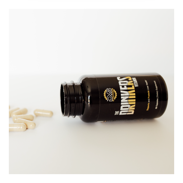 Tipped over bottle of The Drinkers Vitamin with capsules spilling out
